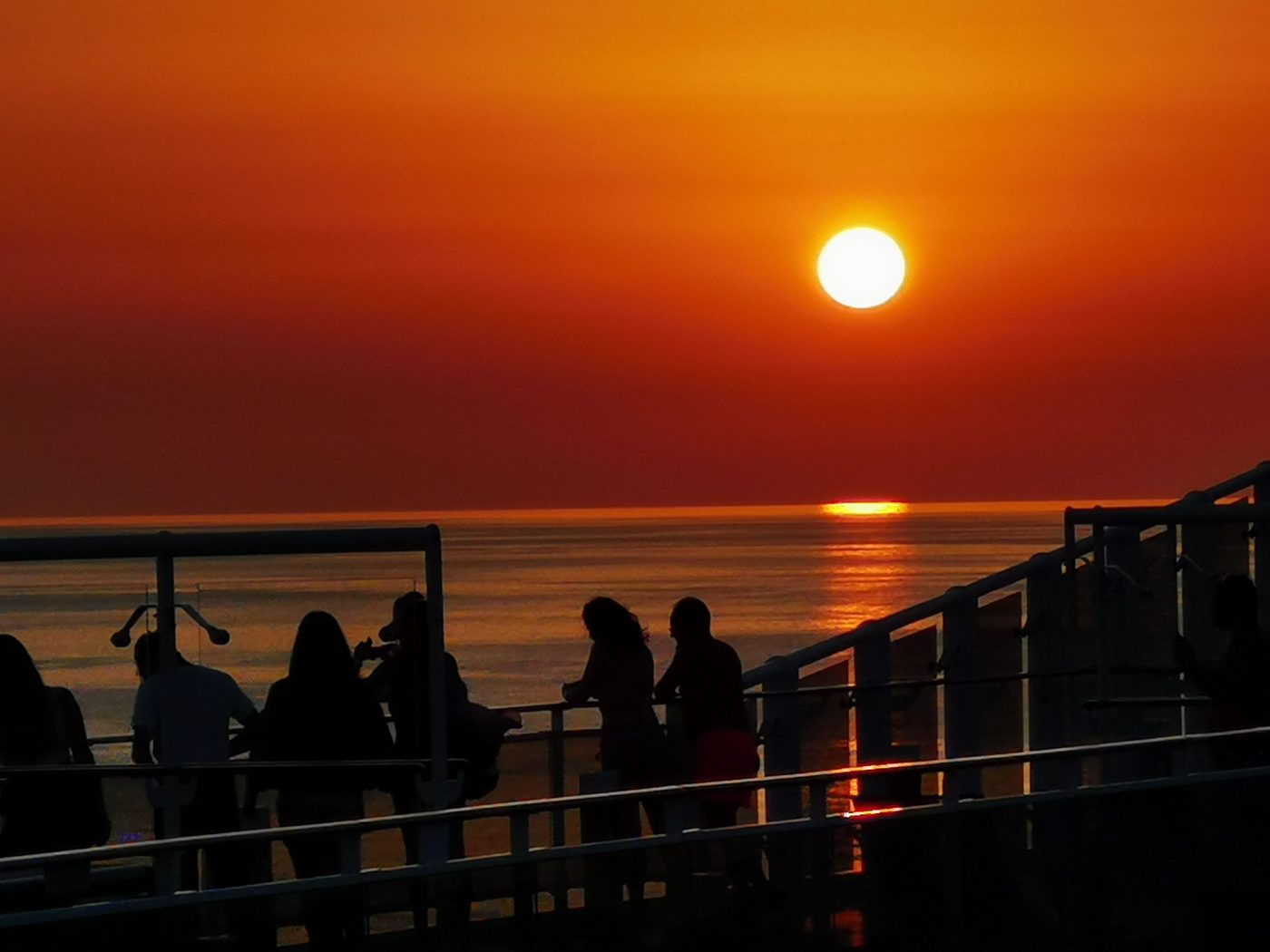 Viaggiatori sul ponte di una nave al tramonto